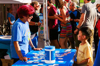 Photo: Event volunteer welcomes a young attendee to the North City Neighborhood Association booth.