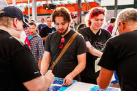 Photo: Sound Transit ambassadors at the "Discover. Stamp. Win!" table, stamping maps for transit enthusiasts.