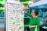 Photo: At the Commute Seattle booth, a visitor engages with a destination map.